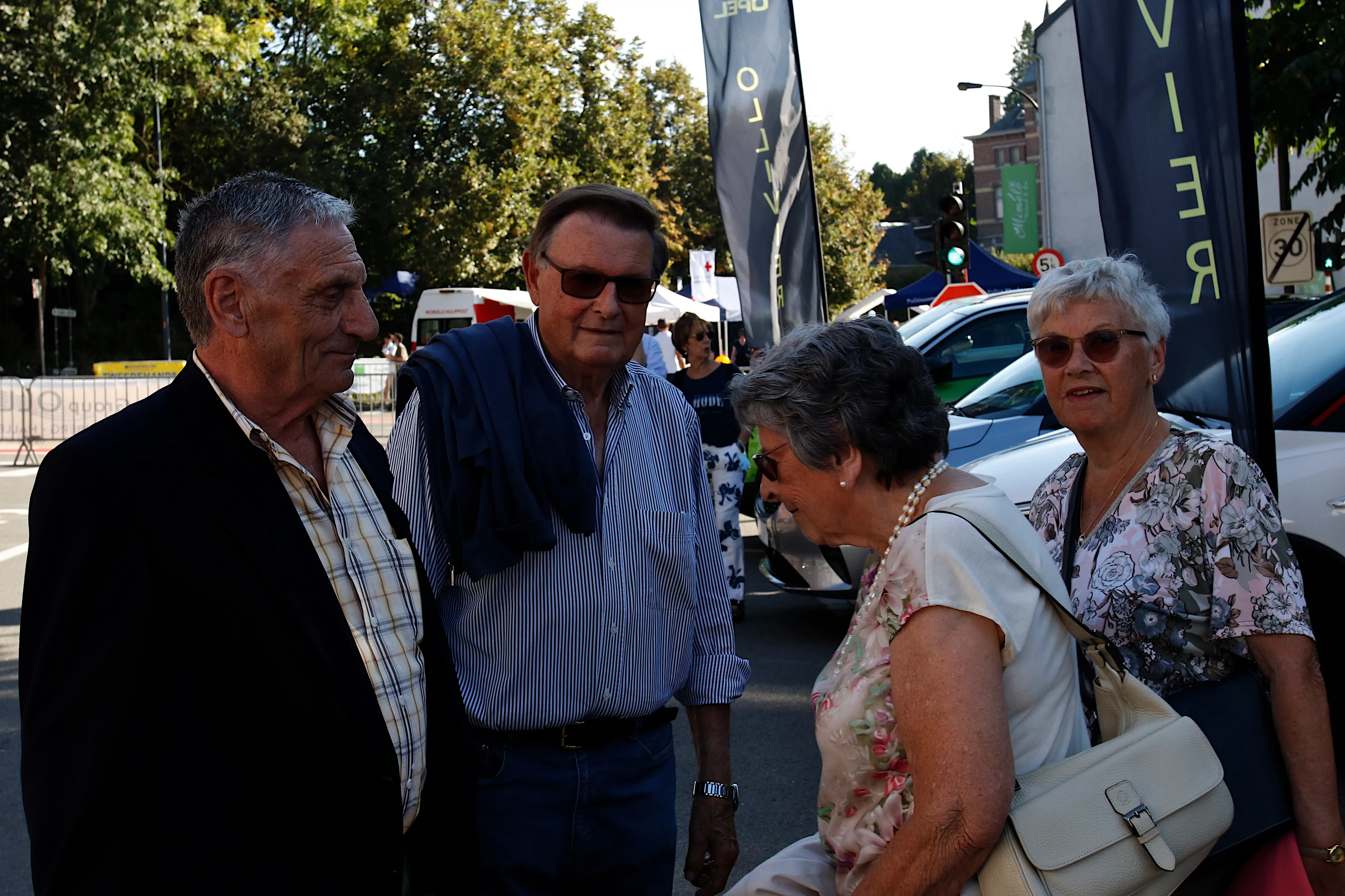 4 mensen aan het genieten aan de parking van de Jaarmarkt van Sint-Genesius-Rode